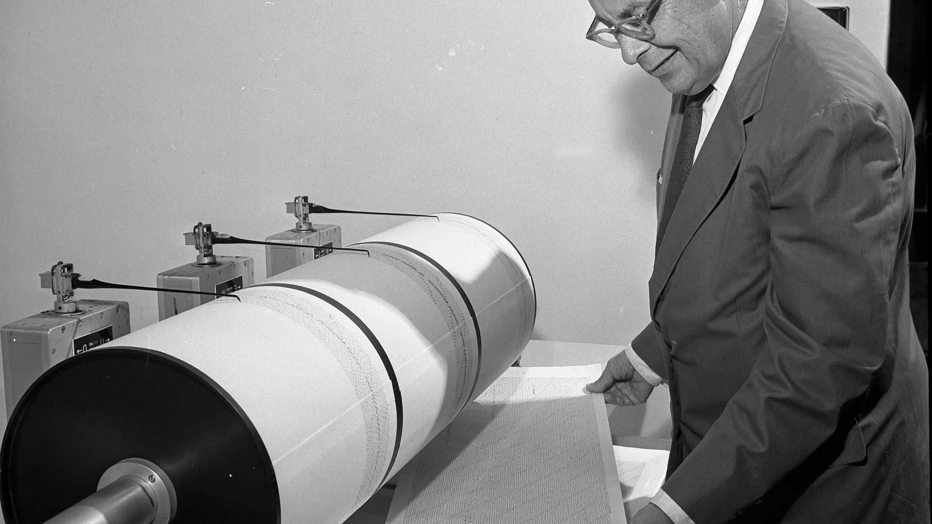 QUIVERINGS—Dr. Charles Richter, one of the world's leading earthquake experts, studies seismograph log upon which earth movements are recorded. He devised the Richter Scale to measure temblor intensity.