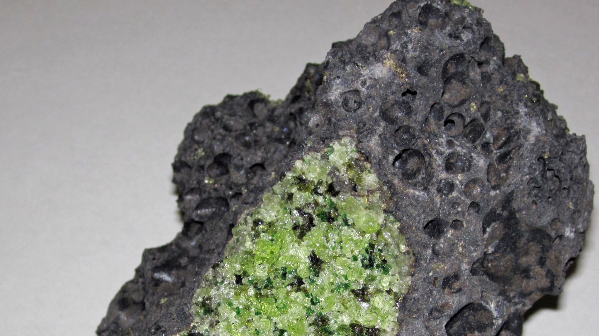 Peridotite mantle xenoliths in vesicular phonotephrite from the Pleistocene of Arizona, USA.
Green = peridotite
Gray = phonotephrite host rock
“Peridot” is a gemological term for gem-quality forsterite olivine, but it does not differ in any chemical sense