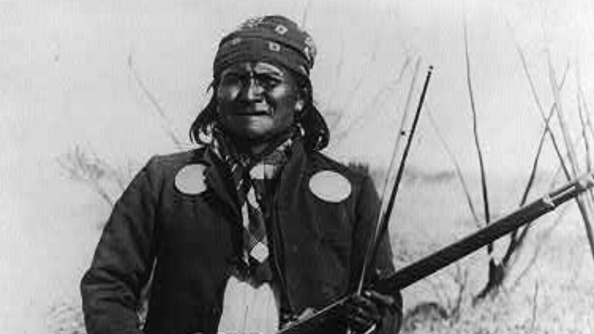 Scene in Geronimo's camp...before surrender to General Crook, March 27, 1886: Geronimo, full-length portrait standing, facing left, rifle at port.