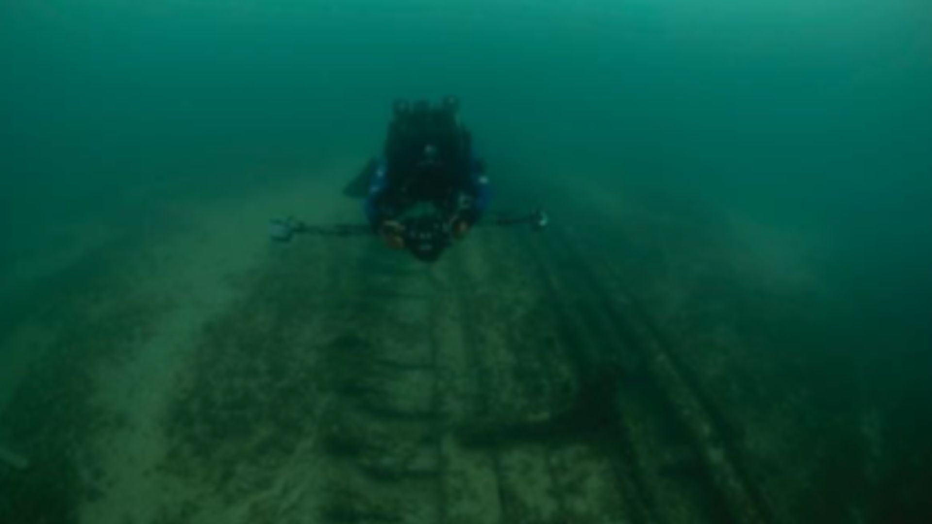 A scuba diver uses laser photogrammetry tools to record dimensions of a shipwreck in a National Marine Sanctuary.