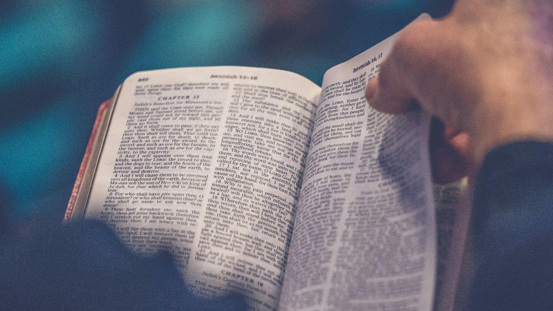 person's hand holding book page
