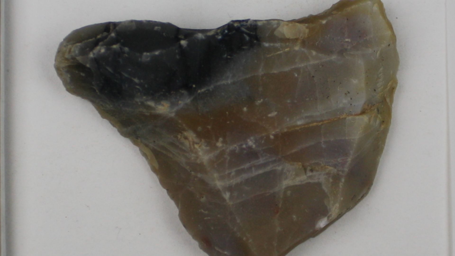 2 novaculite flake tools. The first flake tool is a large utilized and retouched flake that is complete with a plain platform; it measures 76 x 68 x 14 mm and has no cortex. The second flake tool consists of the proximal portion of a utilized flake. It me