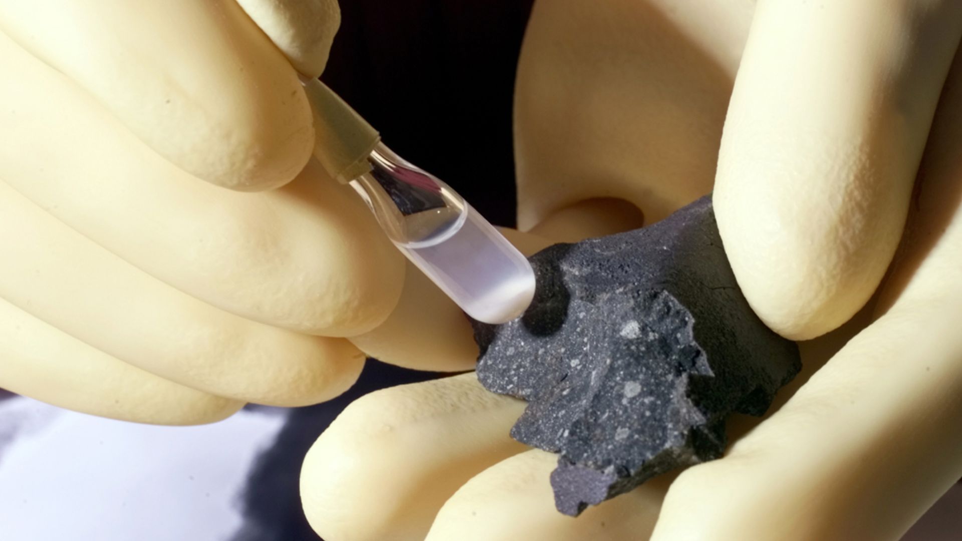Fragment of the Murchison meteorite (at right) and isolated individual particles (shown in the test tube).