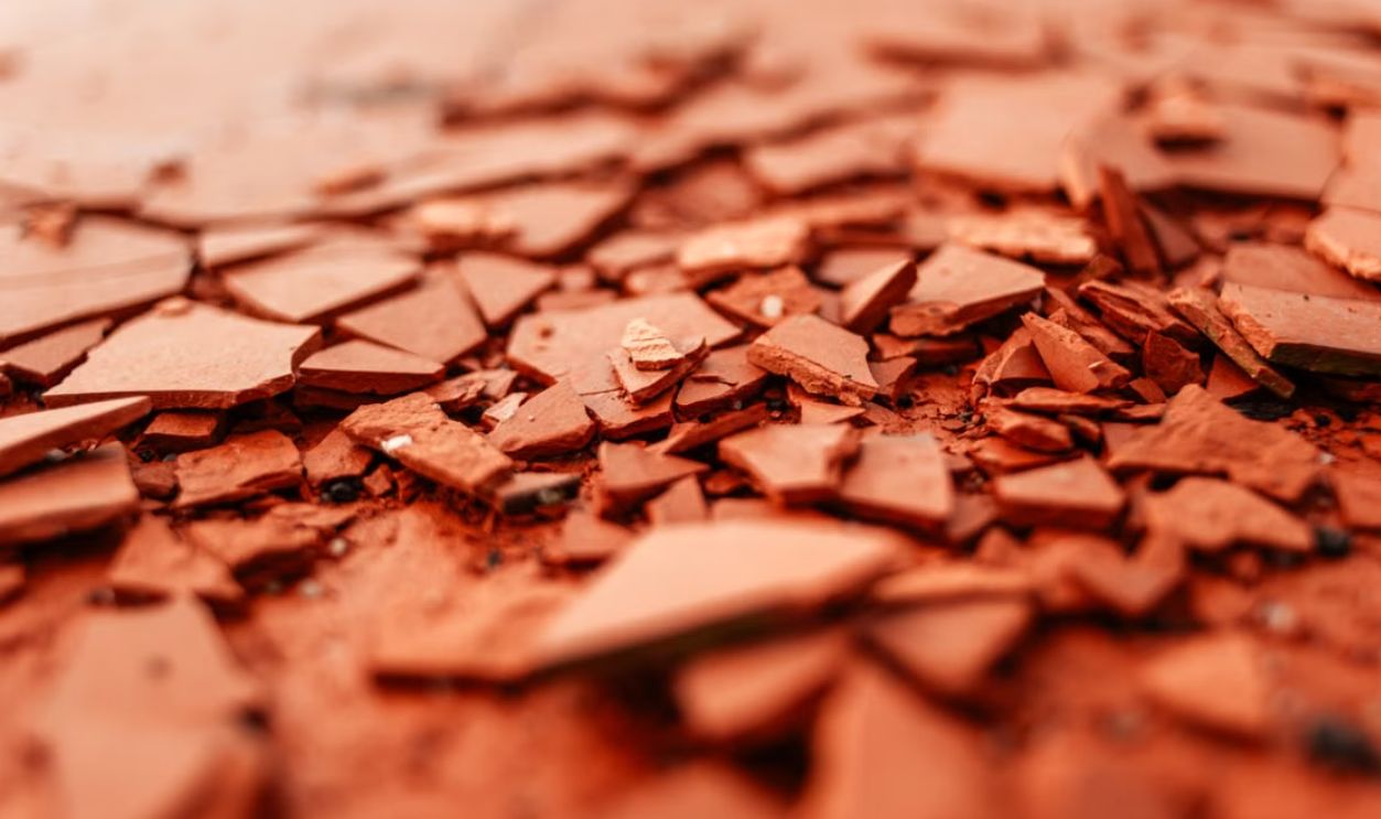 Detailed close-up of red broken ceramics highlighting texture and selective focus