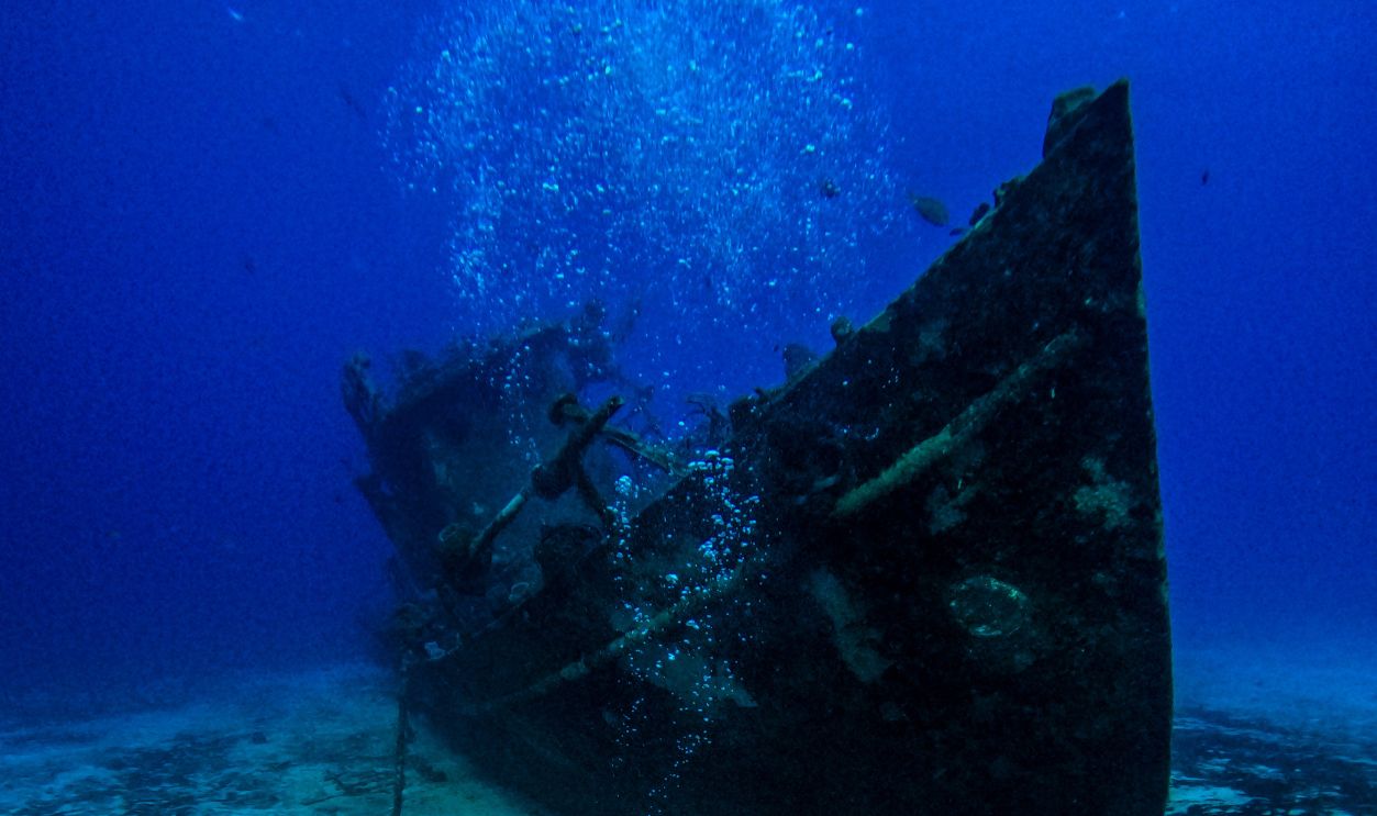 Scuba diver exploring a shipwreck in the clear waters off Cozumel, Mexico. An underwater adventure awaits