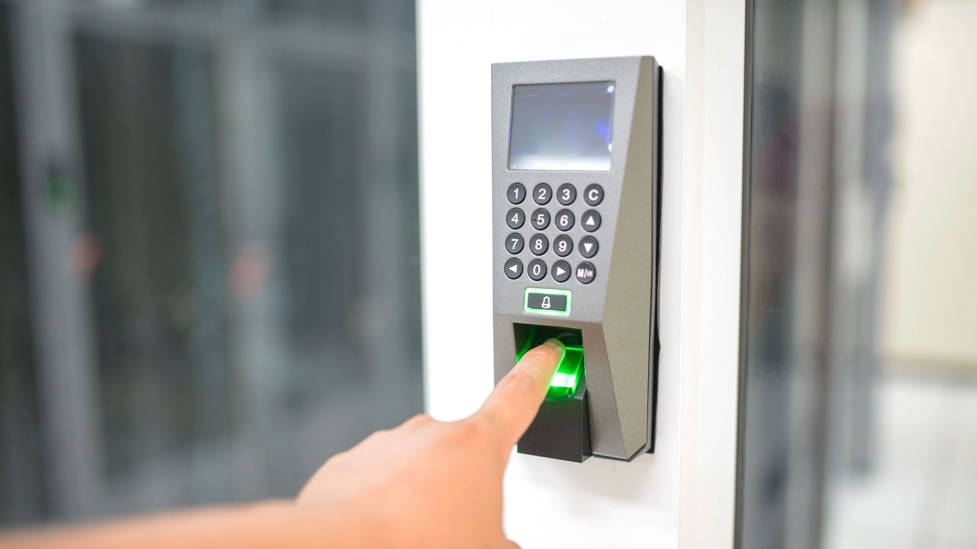 A person uses a fingerprint scanner for secure entry in a business setting.