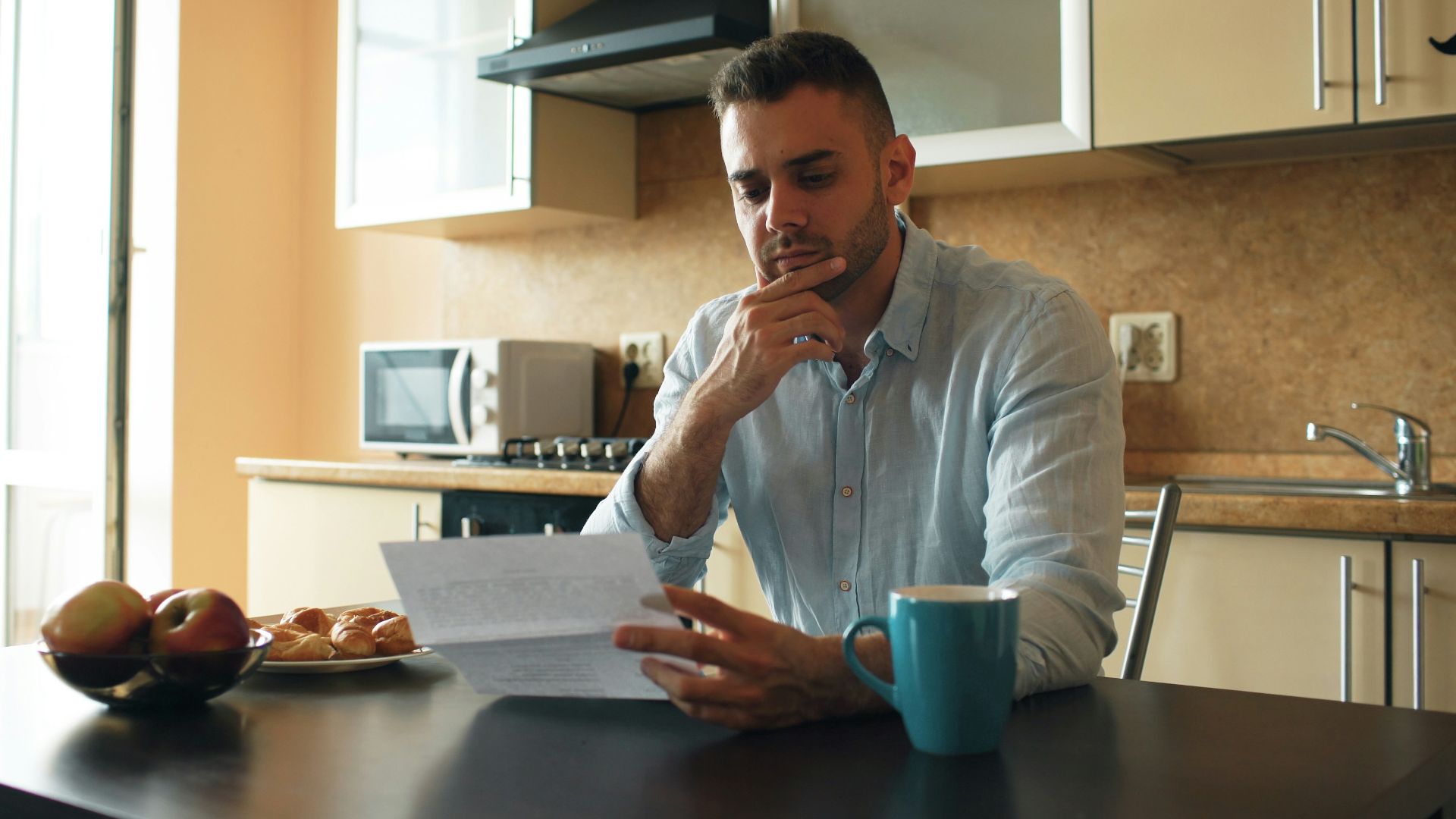 Man reading a document in a kitchen