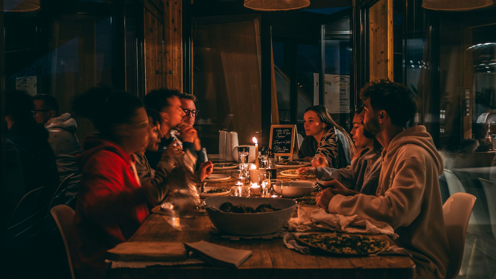 People enjoying a candlelit dinner at a dimly lit restaurant.