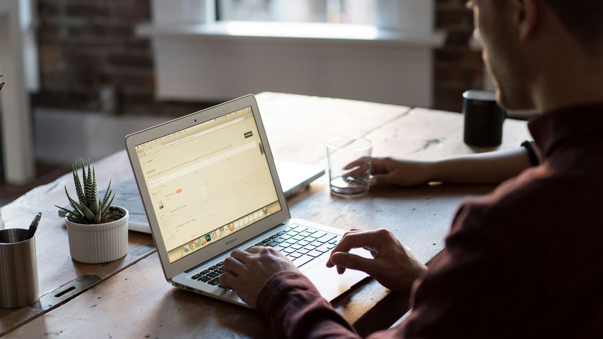 man operating laptop on top of table