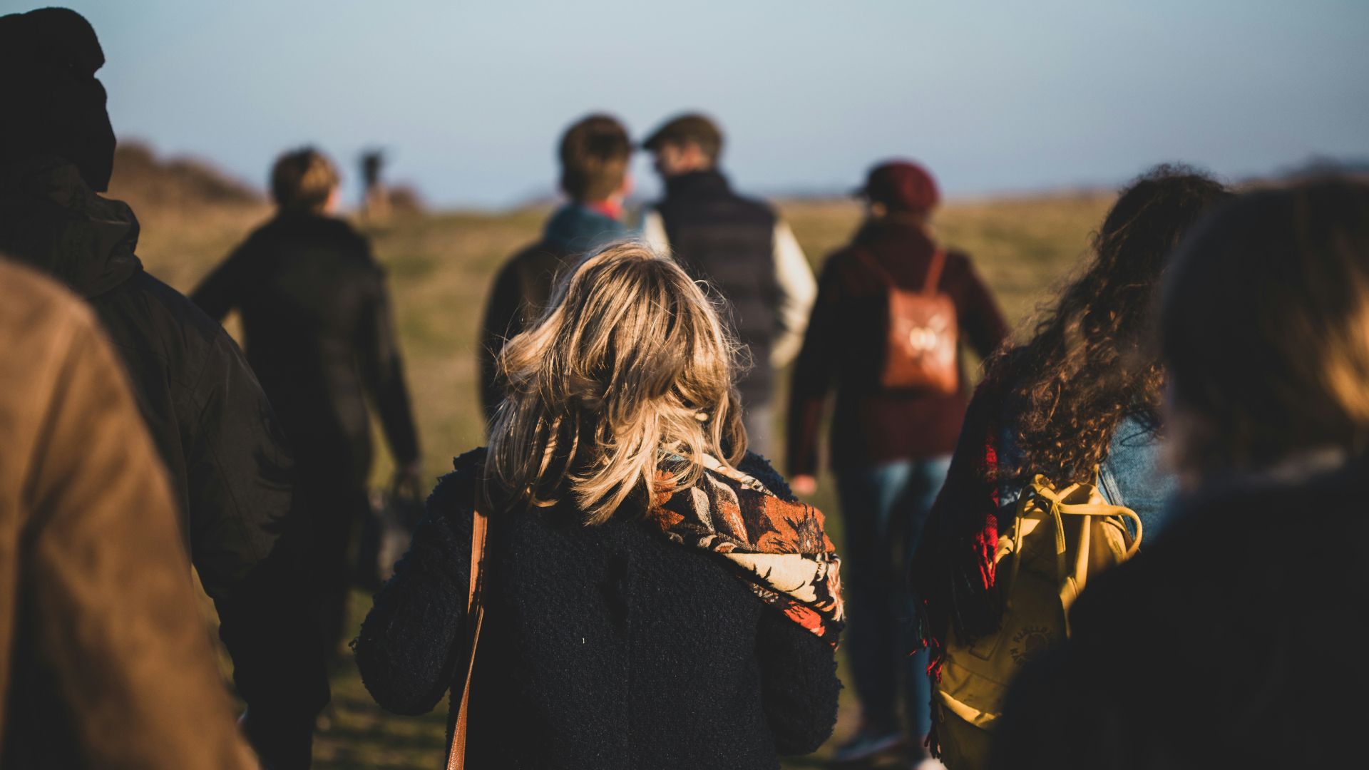group of people walking on grass field