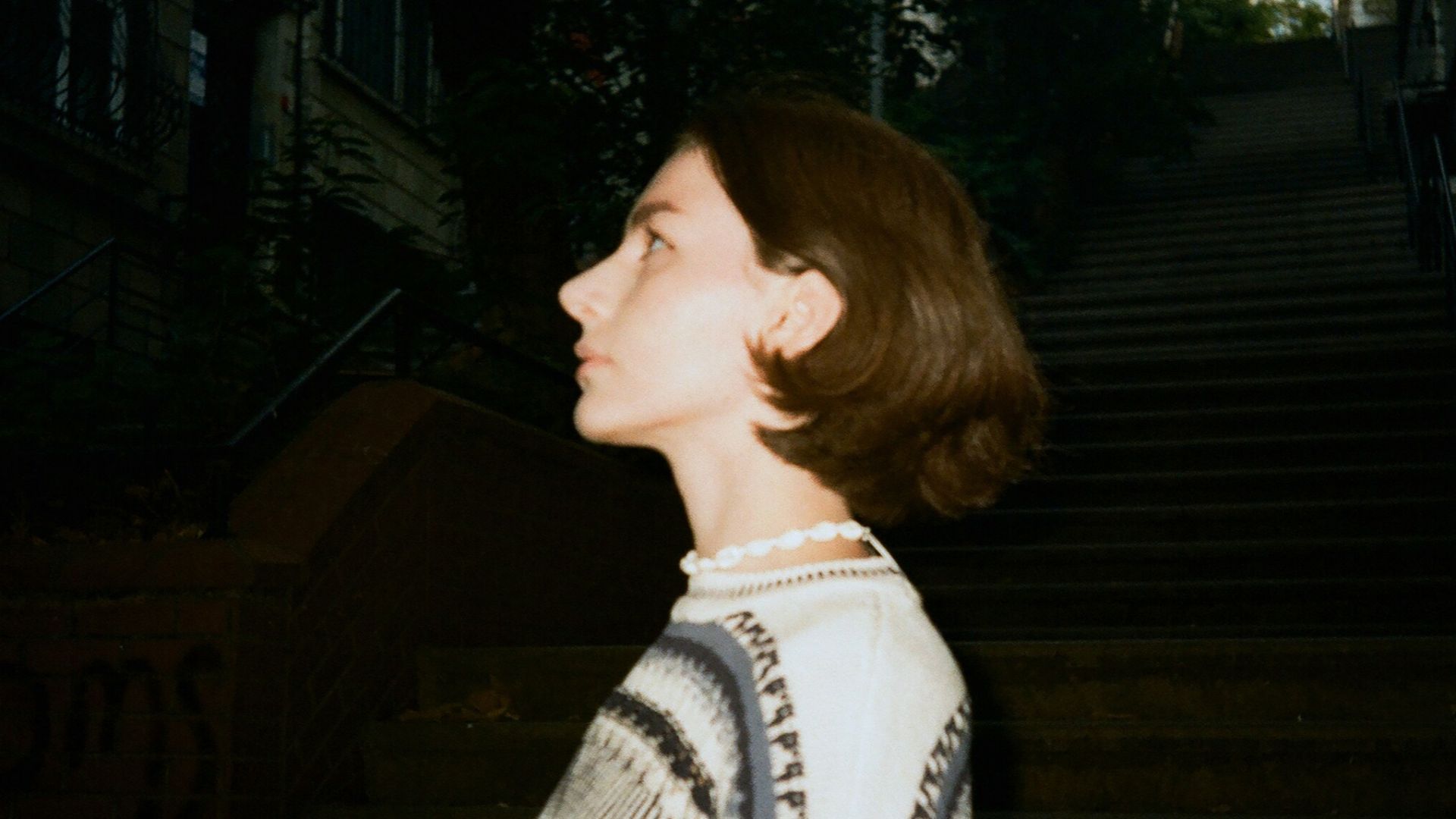 A woman standing in a dark alley way
