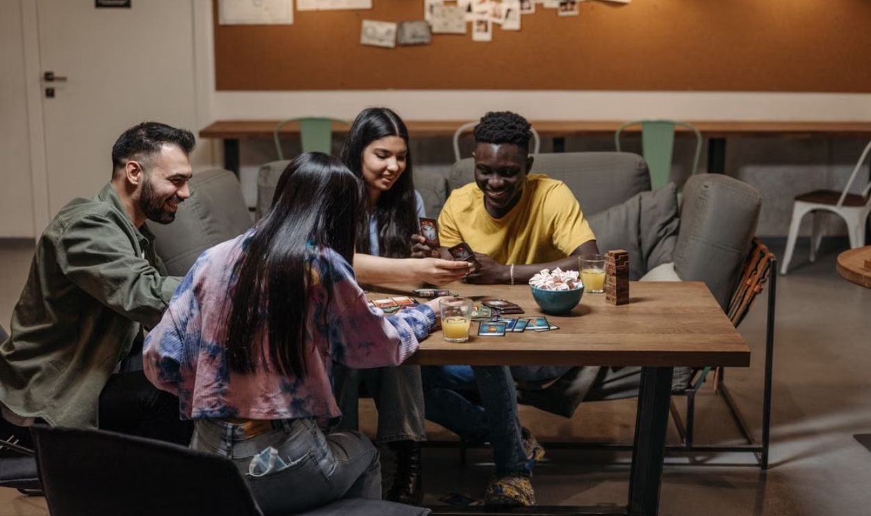 A group of friends enjoying a card game together in a cozy indoor setting, laughing and interacting
