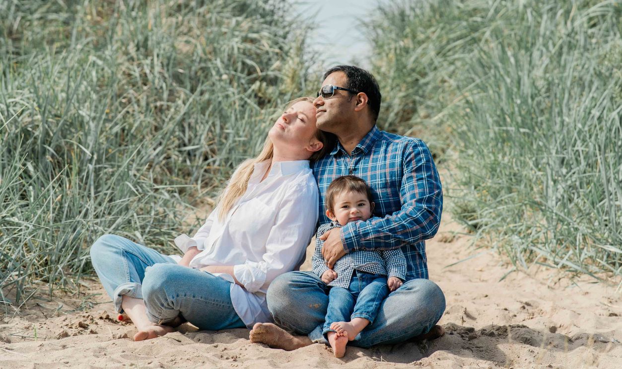 A family of three enjoys a relaxing day on the beach