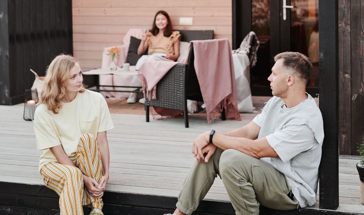 Family enjoying time together on a wooden patio with warm lights at dusk