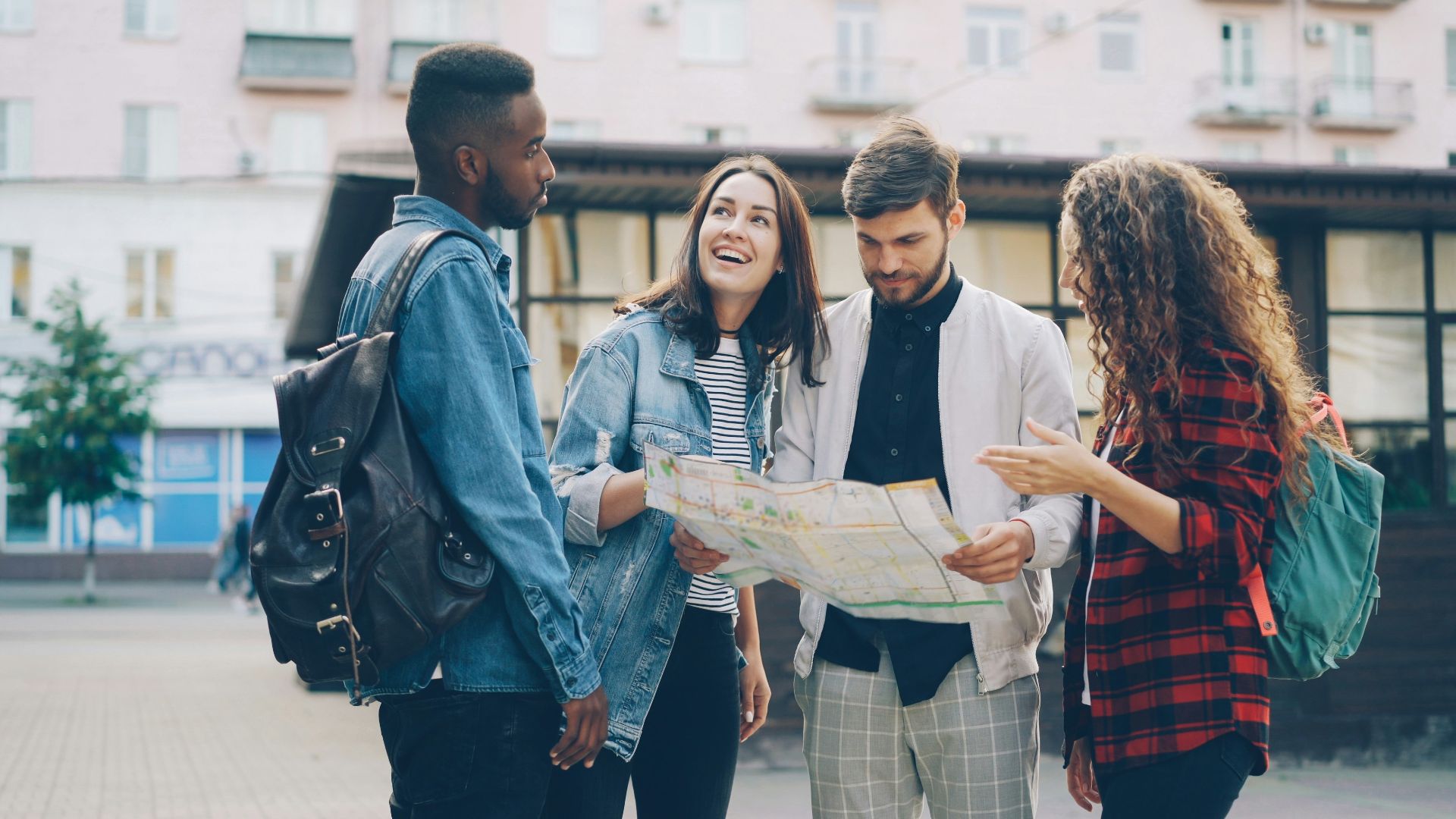 Friends study a map together while traveling.
