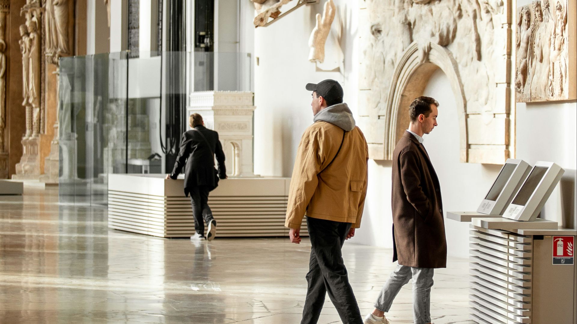 a couple of people walking through a museum