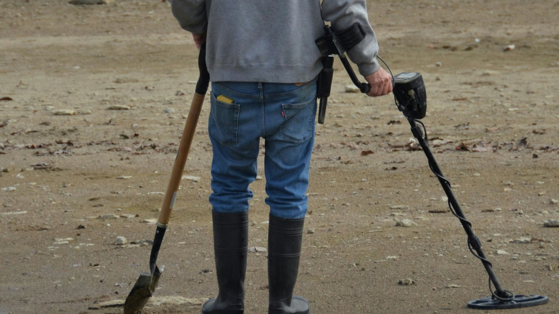 a man with crutches and a cane standing on a beach