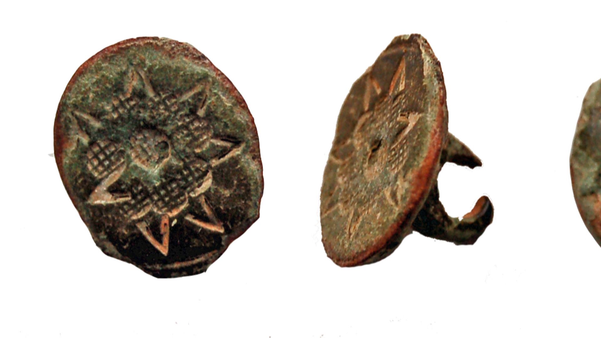 Cast copper alloy button length 14mm, width 12mm, thickness 9mm, weight 1.71g.  Seven petaled flower with a star burst behind on the face, integral loop on the reverse.  
Date 17th century .