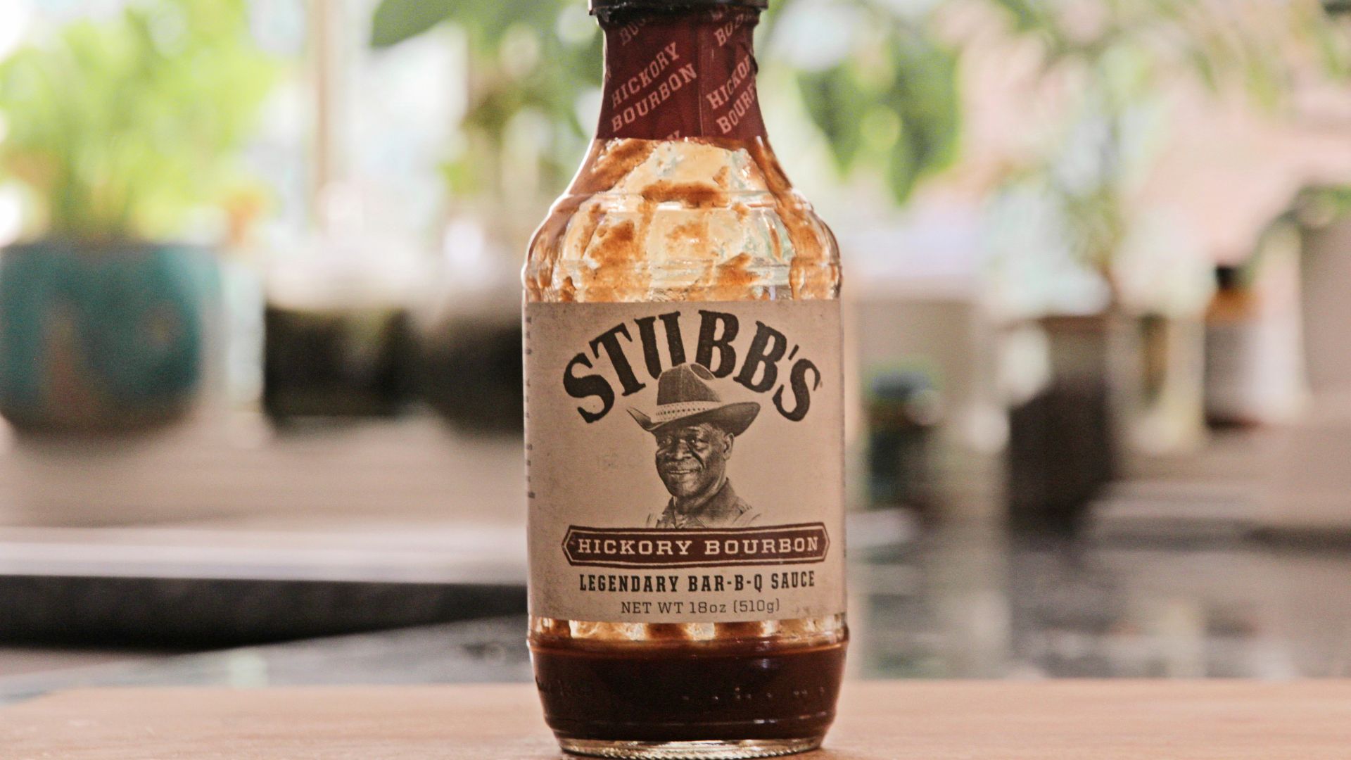 a bottle of hot sauce sitting on top of a wooden table
