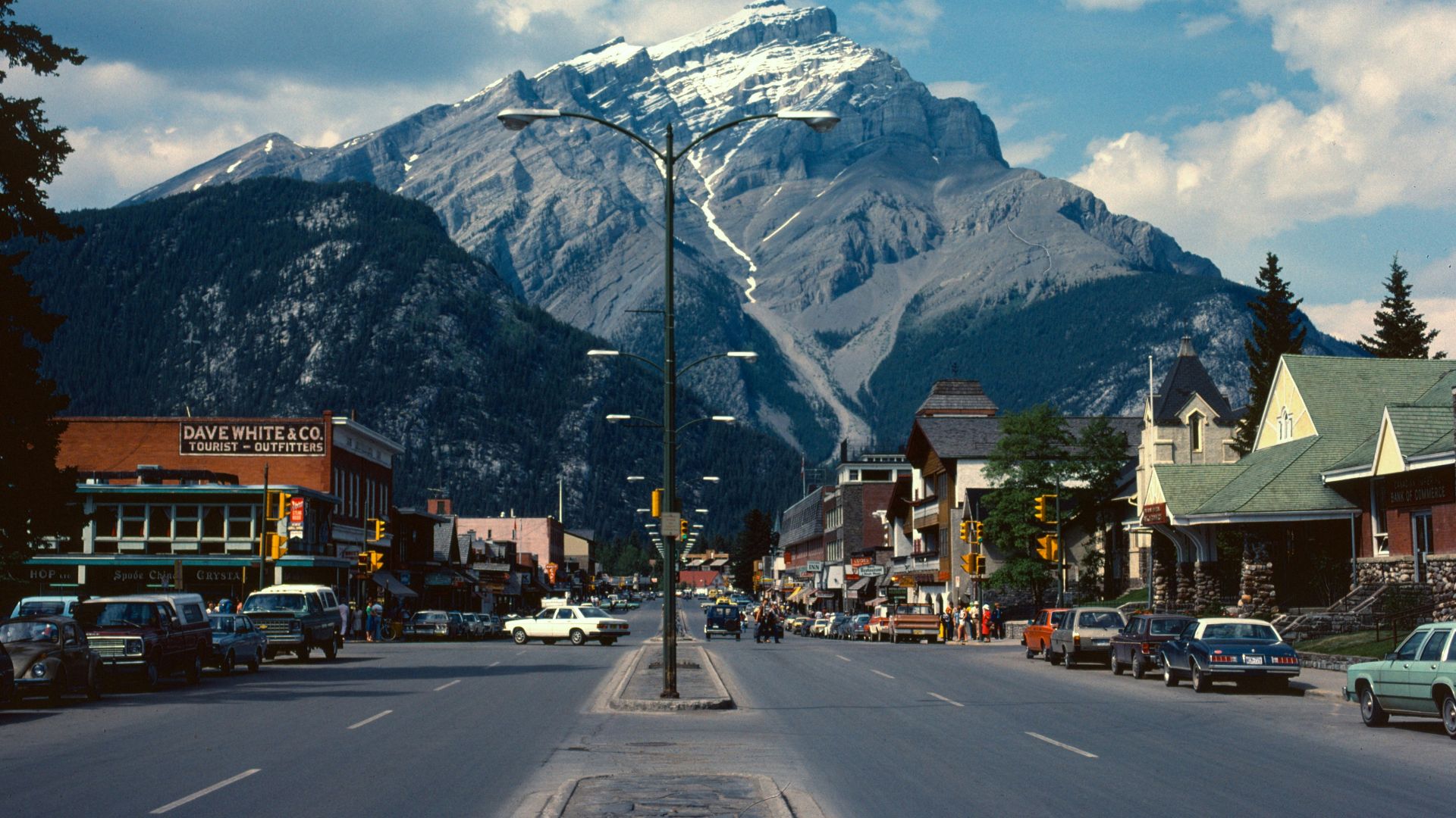 cars parked beside road near mountain