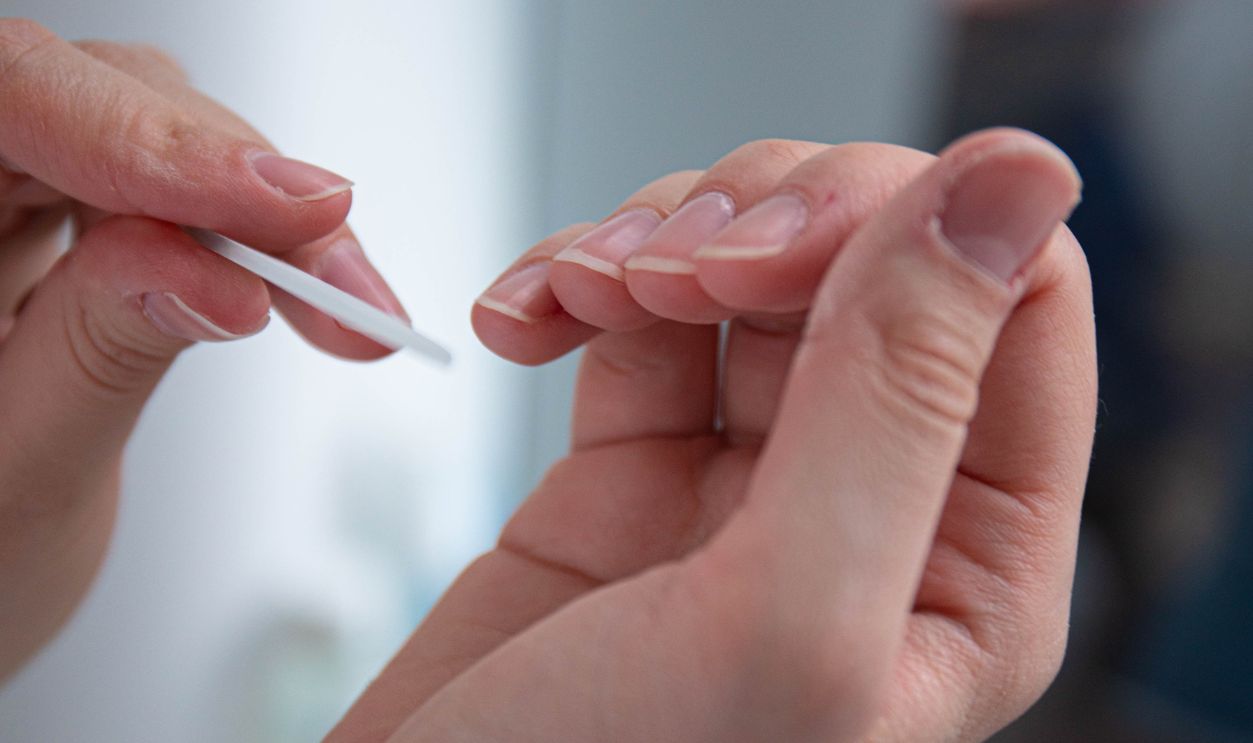 Detailed close-up of a woman maintaining her nails, focusing on personal grooming and self-care.
