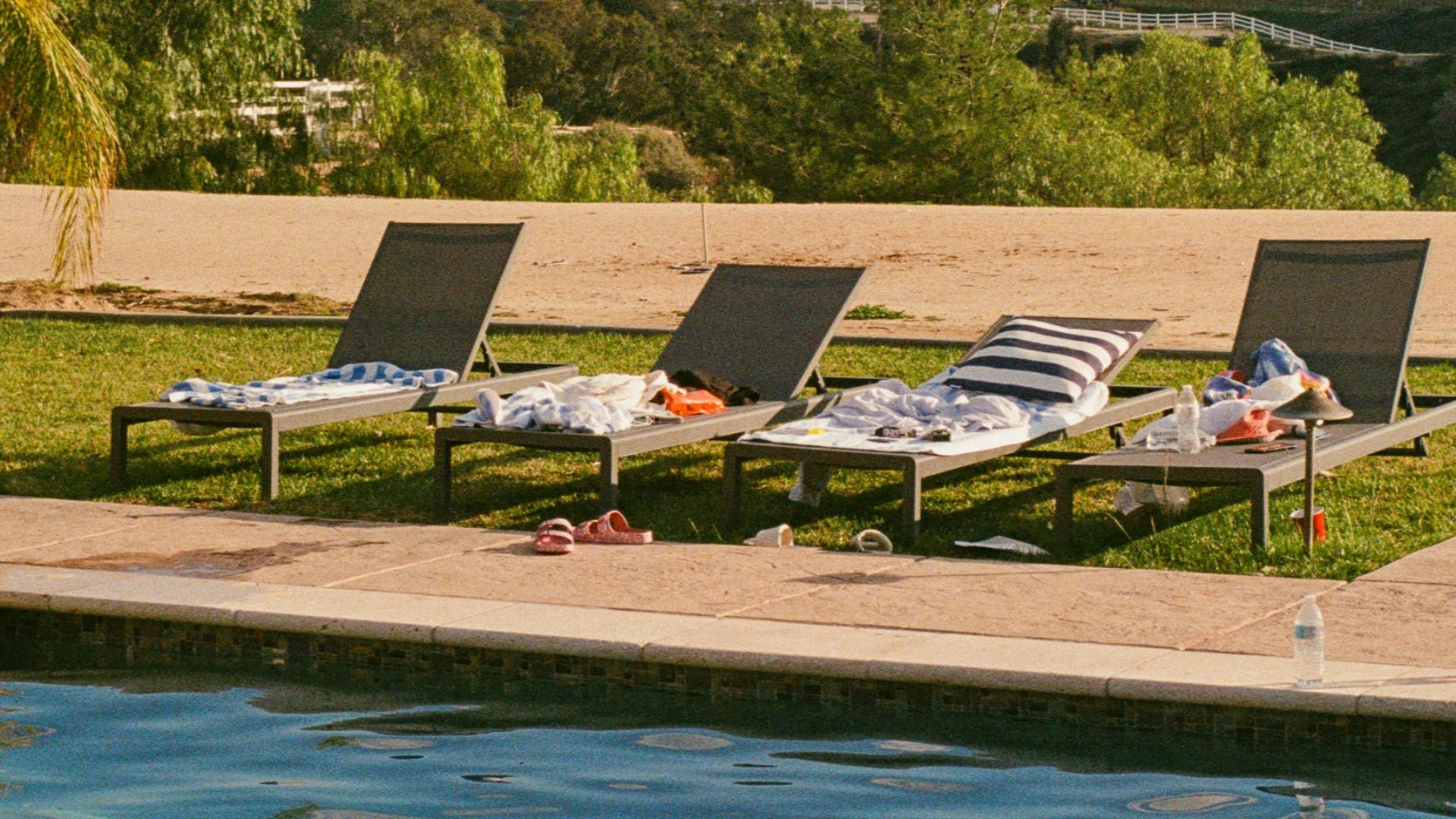 a couple of lawn chairs sitting next to a swimming pool
