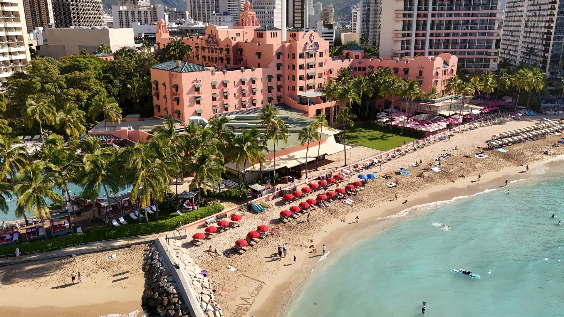 Beautiful beach scene with a resort and city skyline.