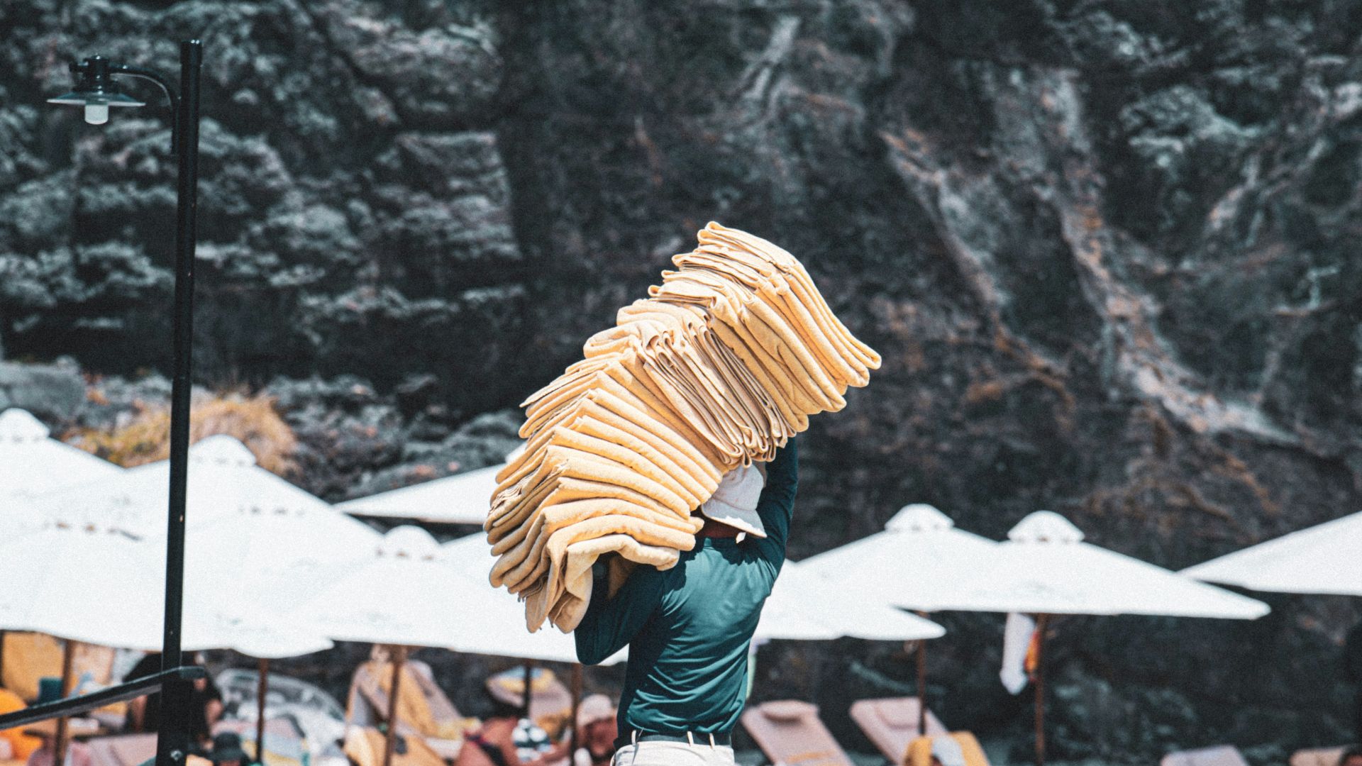 Man carrying towels on a sunny beach resort