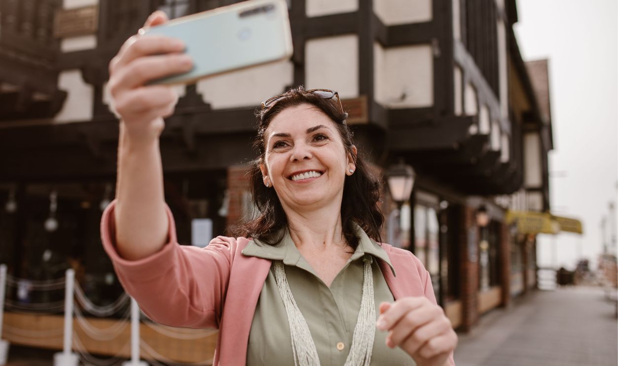 Caucasian woman happily takes a selfie in an urban setting