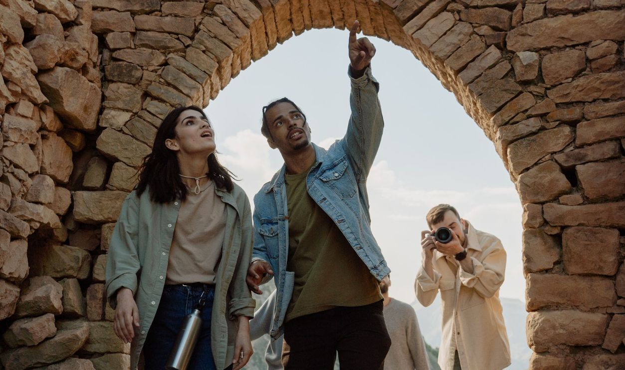 Group of tourists exploring ancient stone ruins with a photographer