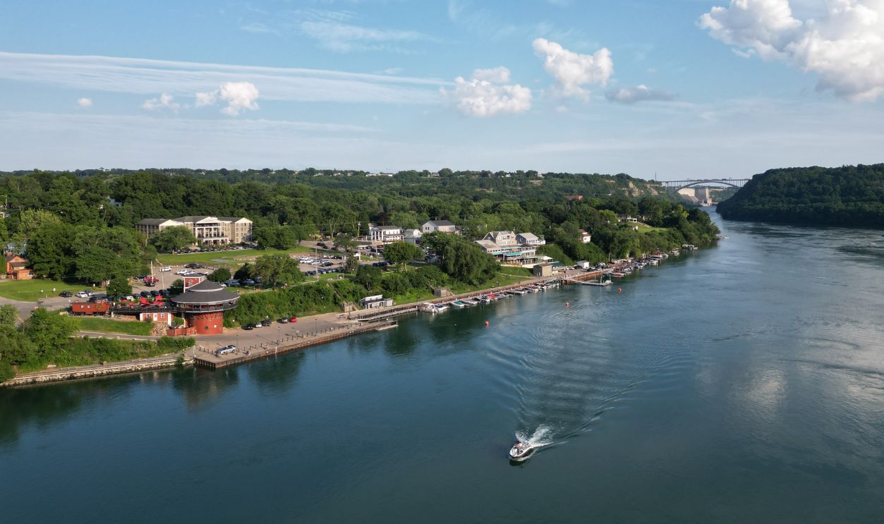 Aerial of the Niagara River and a boat at the village of Lewiston and the international border with Canada Queenston-Lewiston bridge in New York, United States, on a summer afternoon in July, 2024.