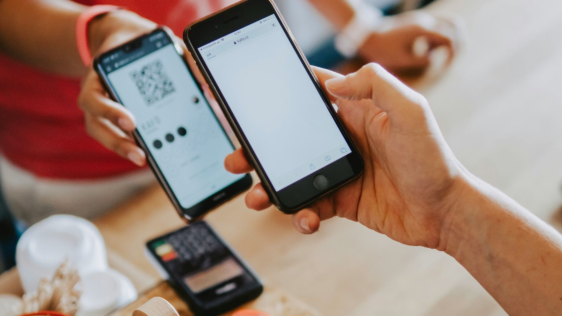 two person's hands holding turned-on phones