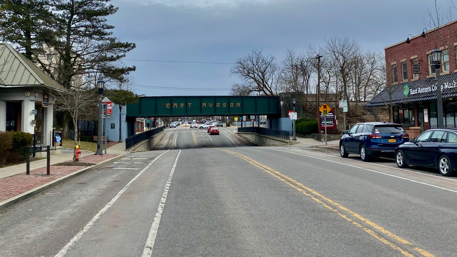 As seen in February 2023, this overpass bridge carries the tracks of the former Pennsylvania Railroad over Main Street in the village center of East Aurora, New York. The Arts & Crafts-derived typeface of the text on the bridge, a common sight in the vill