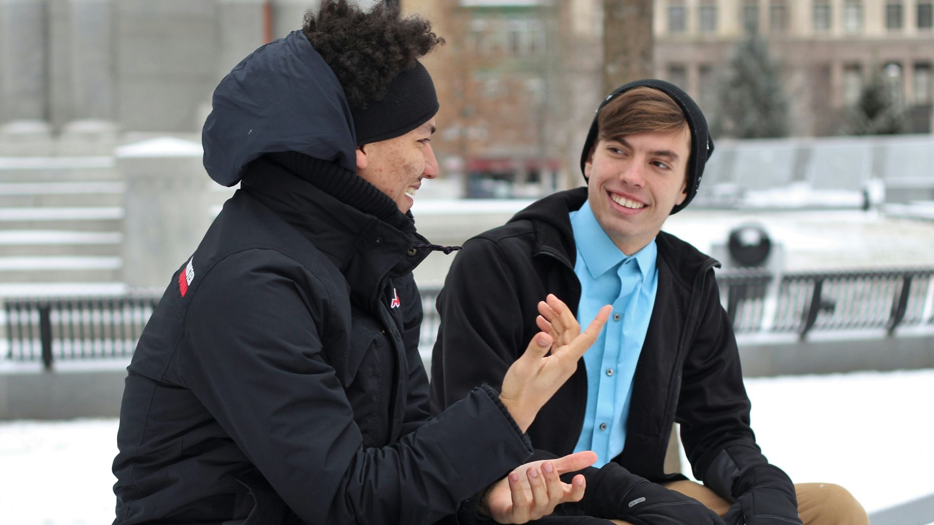 two men talking while sitting on bench
