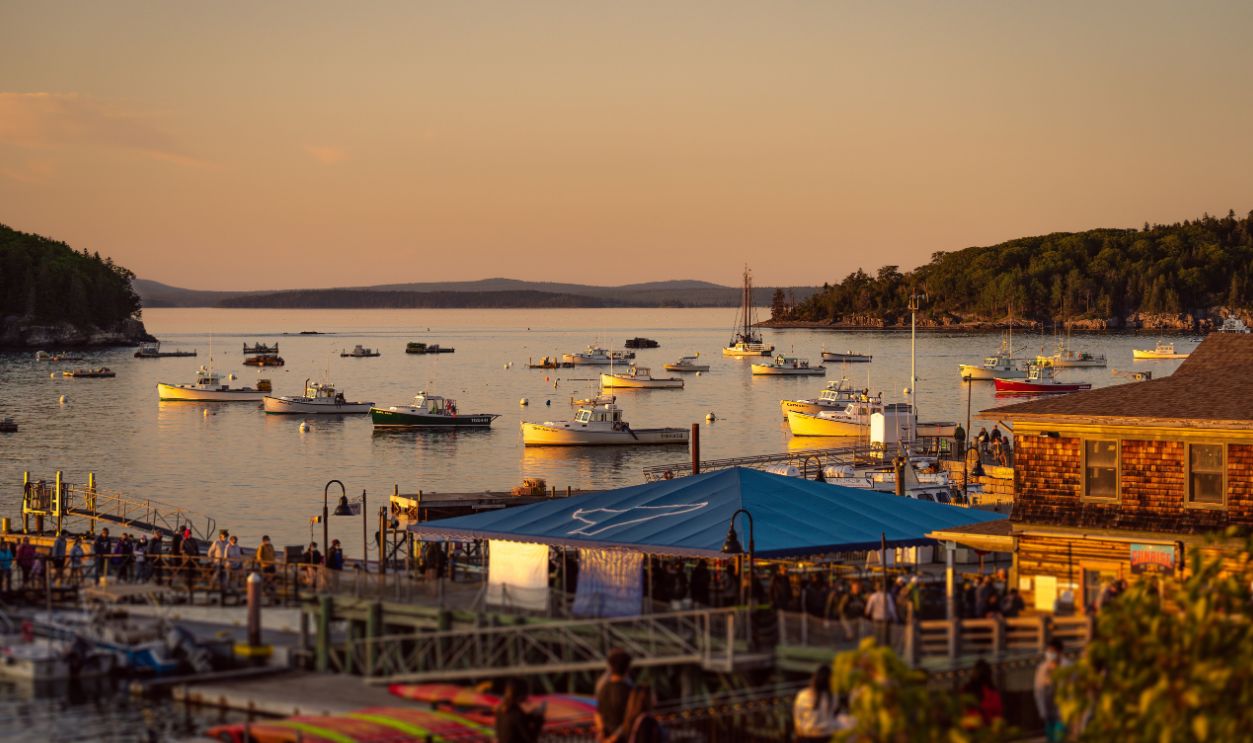 A picturesque view of boats anchored in a harbor during sunset, capturing the essence of coastal serenity
