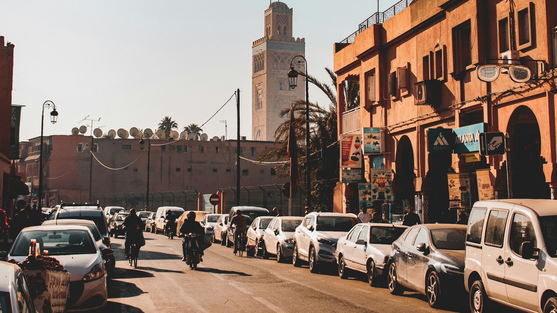 cars parked on street near brown concrete building during daytime