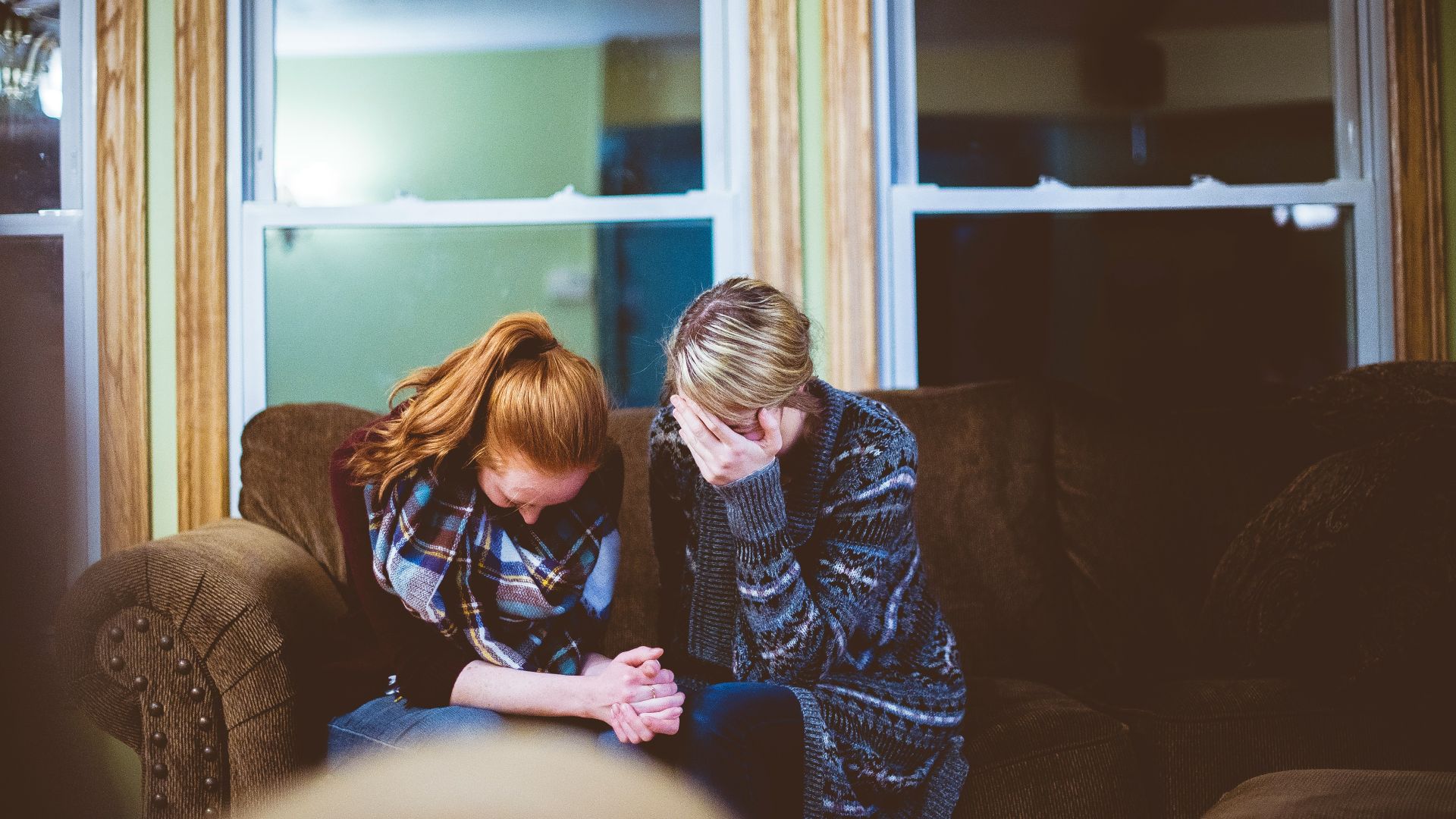 man and woman sitting on sofa in a room