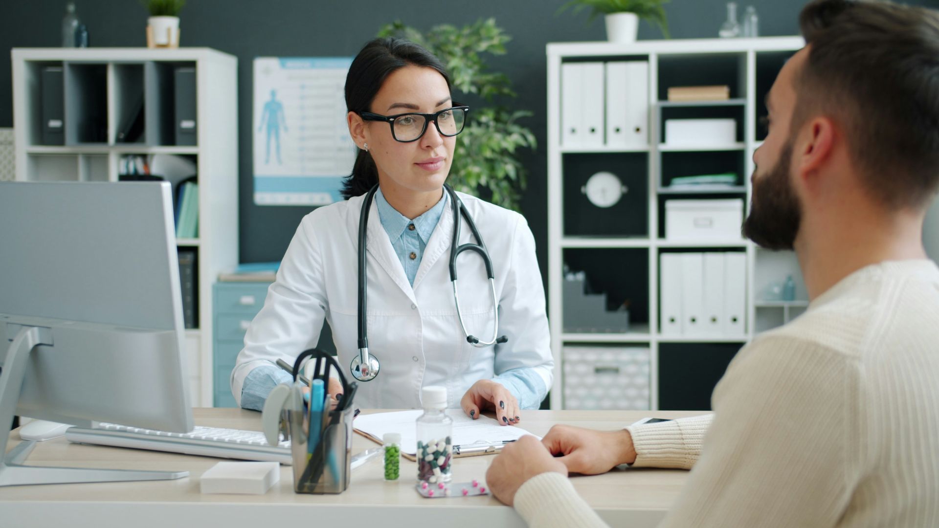 Doctor consults with patient in medical office.