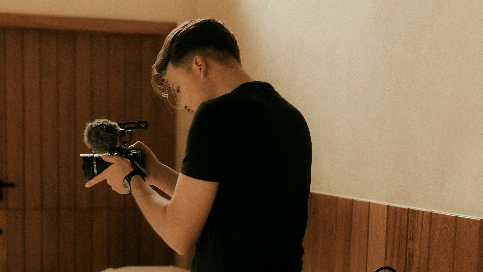 Man filming with a camera in a bedroom