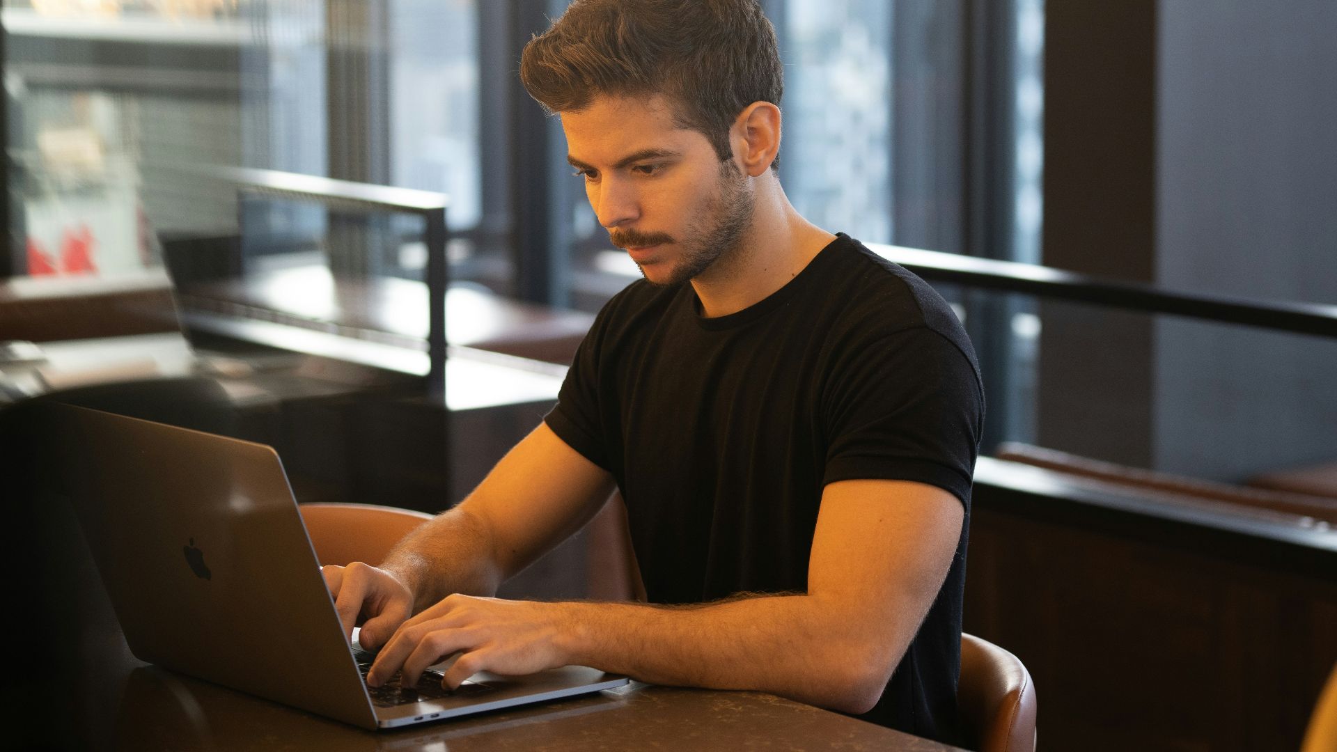 man in black crew neck t-shirt using macbook