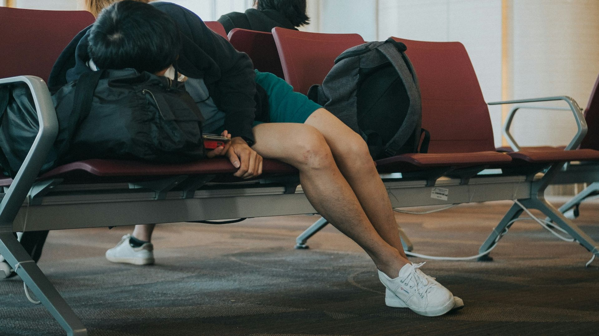 unknown person lying on brown bench indoors