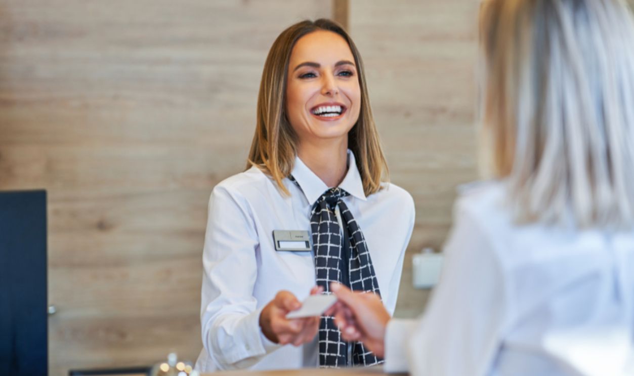 Receptionist and businesswoman at hotel front desk