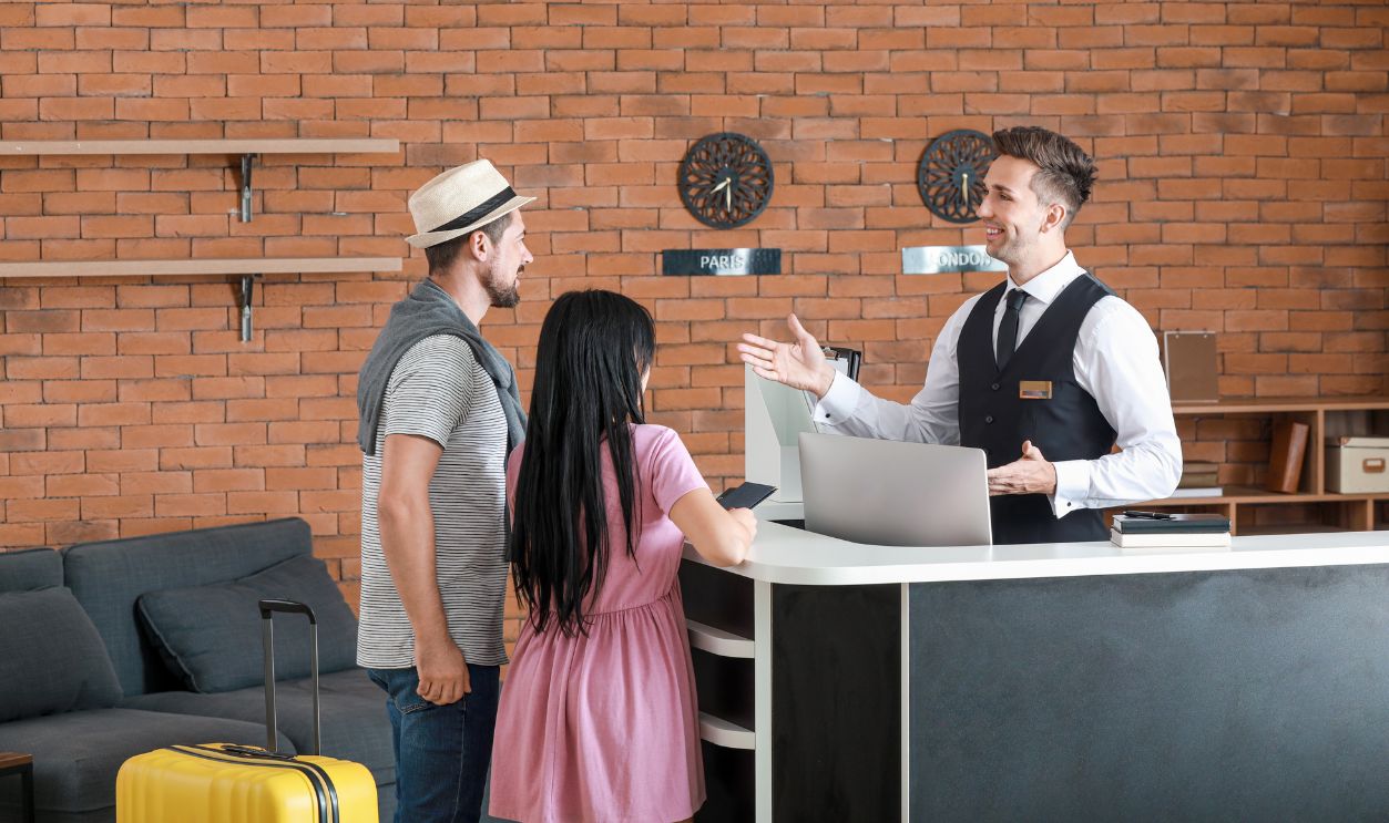 Shutterstock-1633889773, Couple booking room in hotel at reception