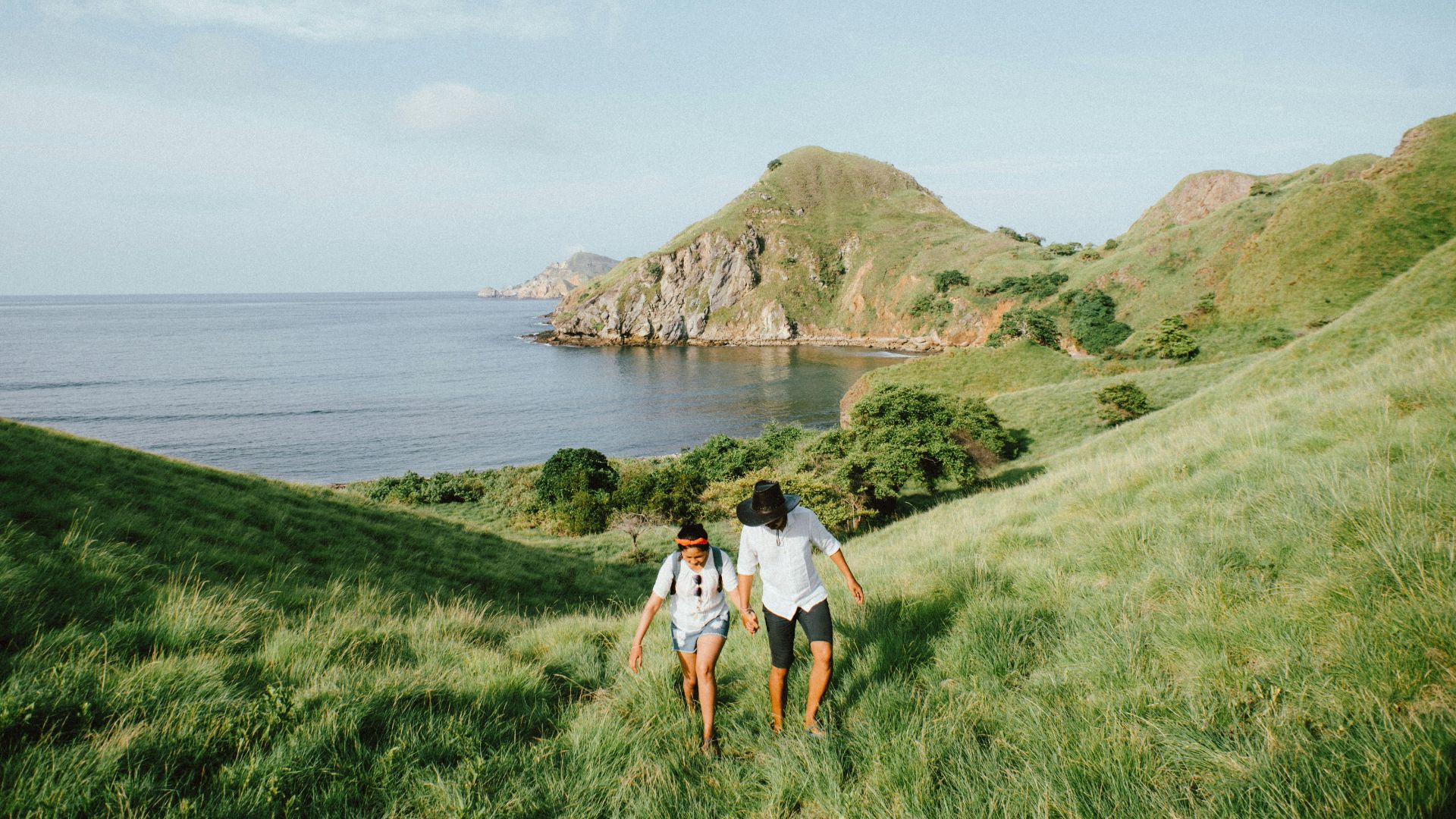 landscape photo of couple walking on green grass
