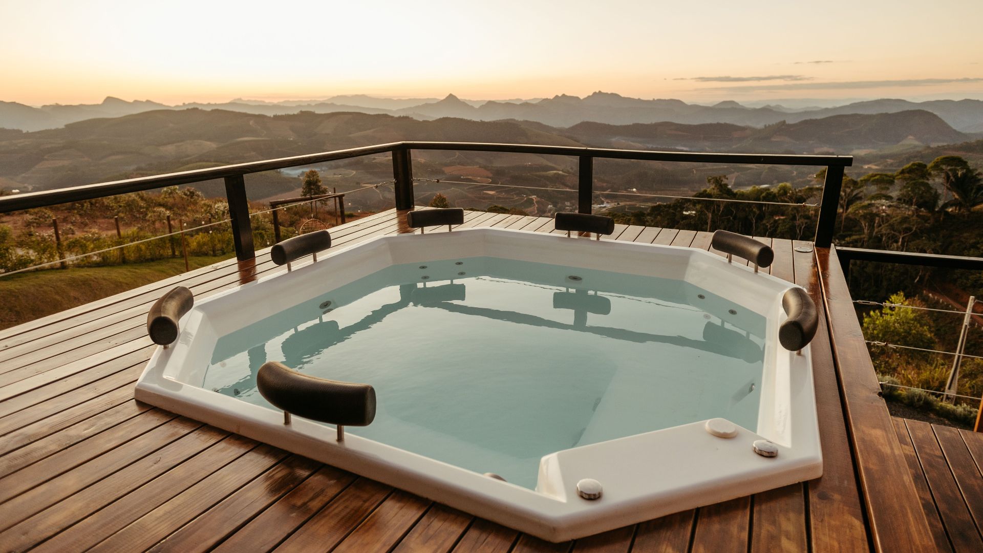 Relaxing hot tub with stunning mountain view at sunset, perfect for luxury retreats.