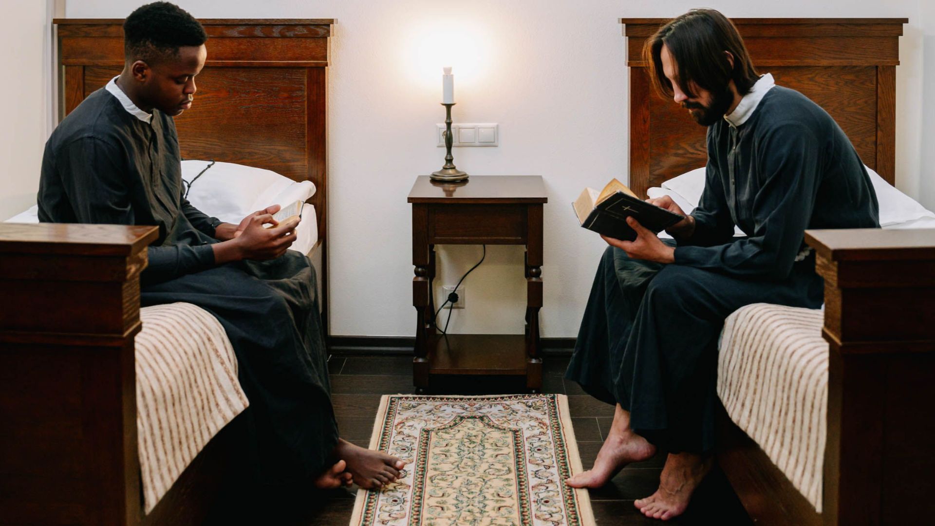 Two seminarians reading bibles in a quiet church dormitory, fostering spirituality.