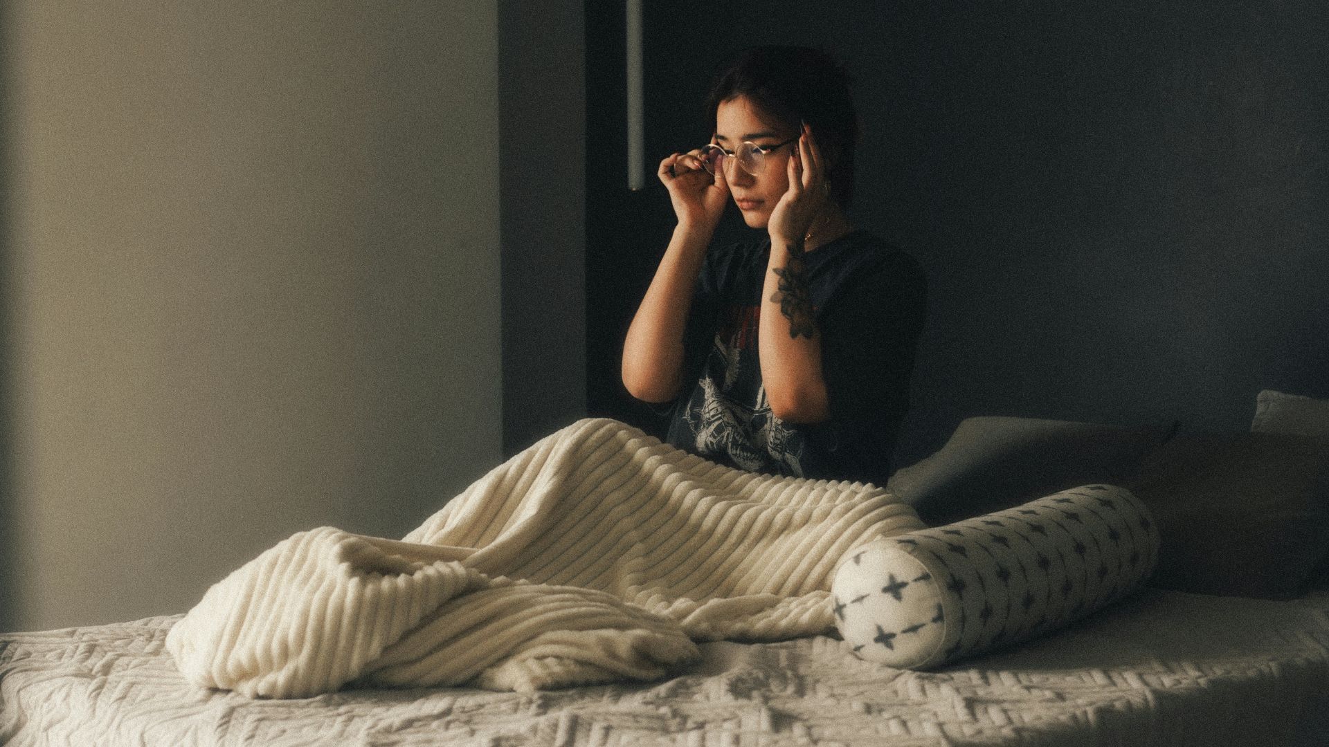 A person sitting on a bed in a room