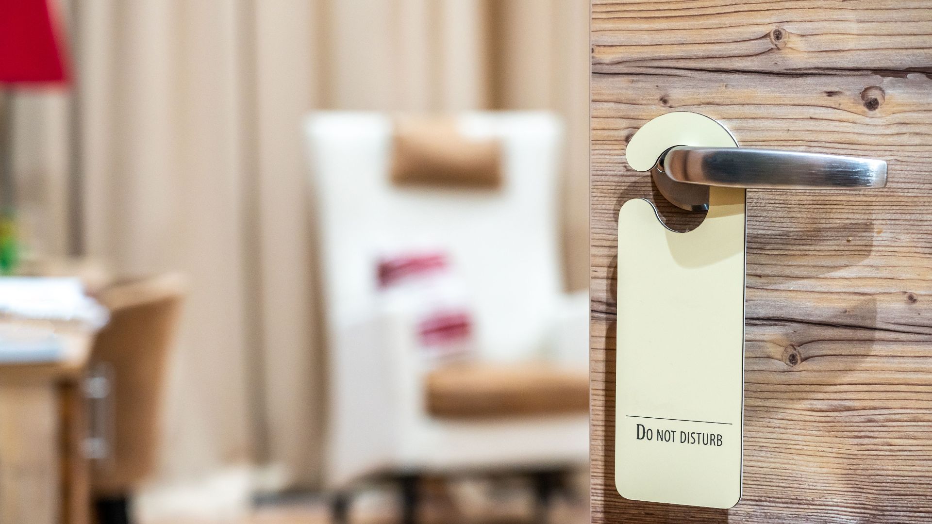 A hotel room door with a 'Do Not Disturb' sign, evoking a sense of privacy and relaxation.