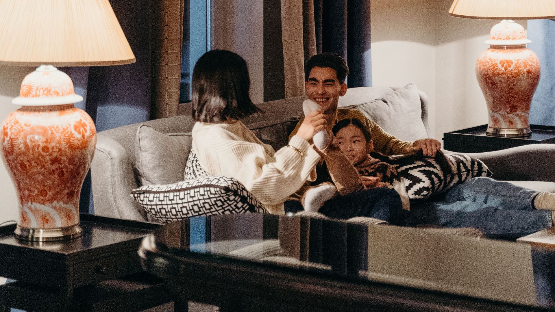 Family engaging in conversation and relaxation in a well-decorated living room.