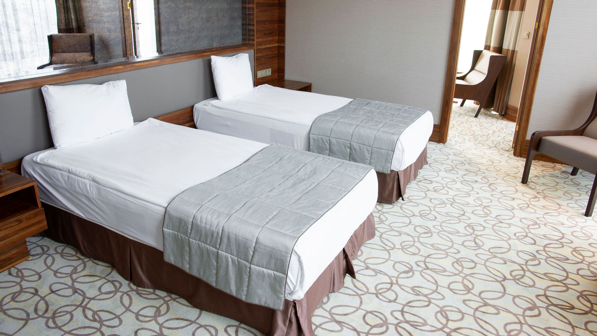 Spacious and luxurious hotel room featuring two comfortable twin beds with stylish design.